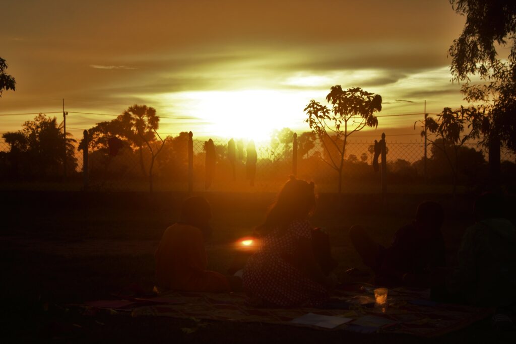 Young children watching the sunset in Southeast Asian country and praying for God's protection
