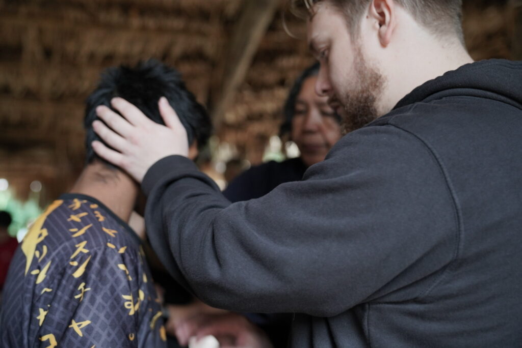 God's provision of miraculous healing: the team laying hands of healing on the chief's son.