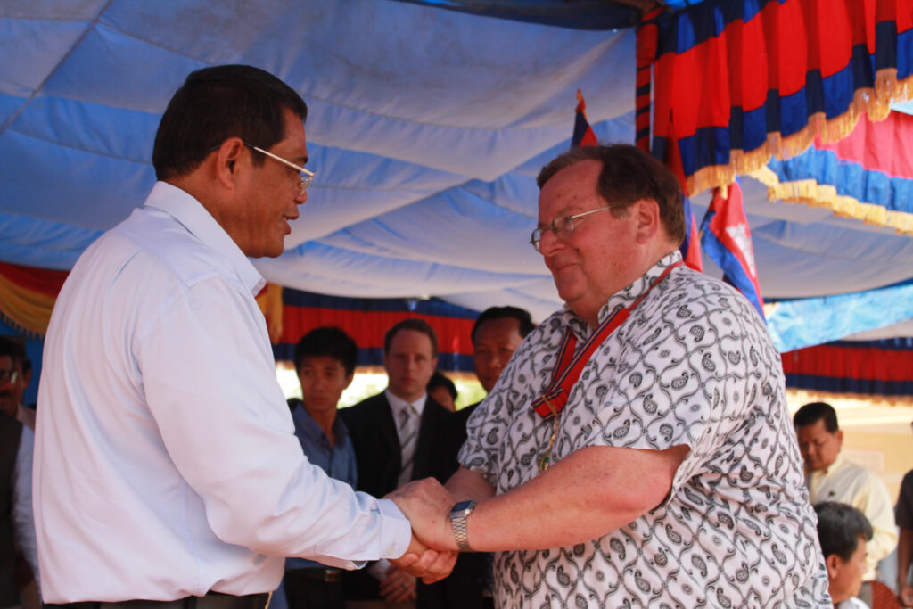 Former Deputy PM Ke Kim Yan presenting Mark Geppert with a Nation Changer award for the Rongko Cluster Schools