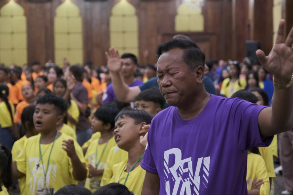 Pastor Sinai worshipping at NHO Kids Camp